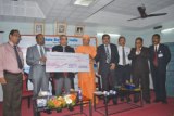 SBI Managing Director A. Krishna Kumar handing over a cheque of 20 lacs to Swami Vishweshananda.  