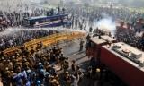 Protestors being sprayed away with water from a fire engine