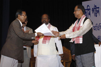 Assam CM Tarun Gogoi handing over a land patta document