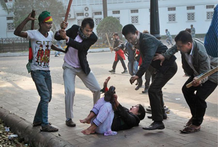 An opposition supporter  being beaten by pro - Government activists